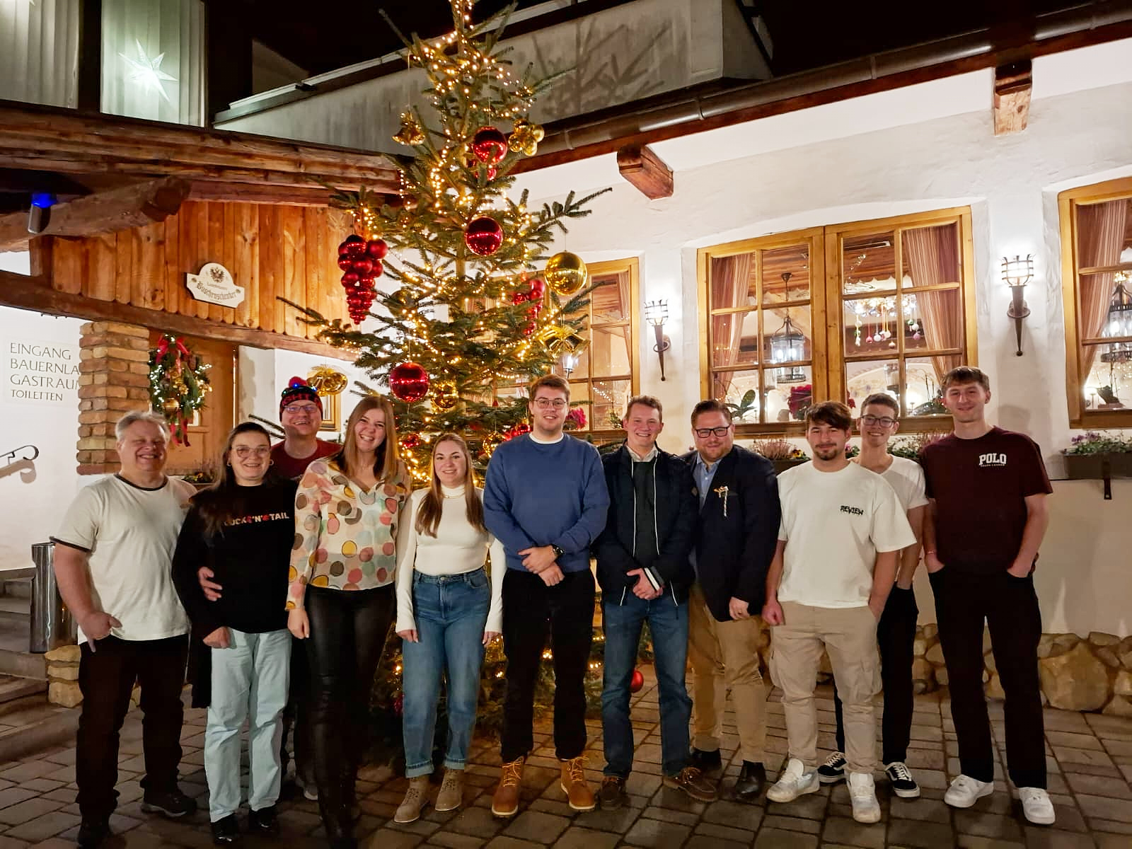 Die Mitglieder des Absolventenvereins vor einem geschmückten Christbaum im Hof des Haurigen Piribauer.